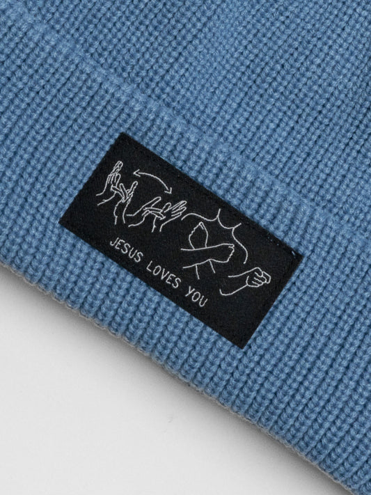 Blue fabric with a black label that says 'Jesus Loves You' on a white background