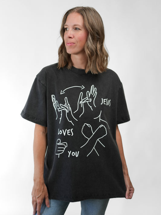 Woman wearing a black t-shirt with white graphics and text on a white background