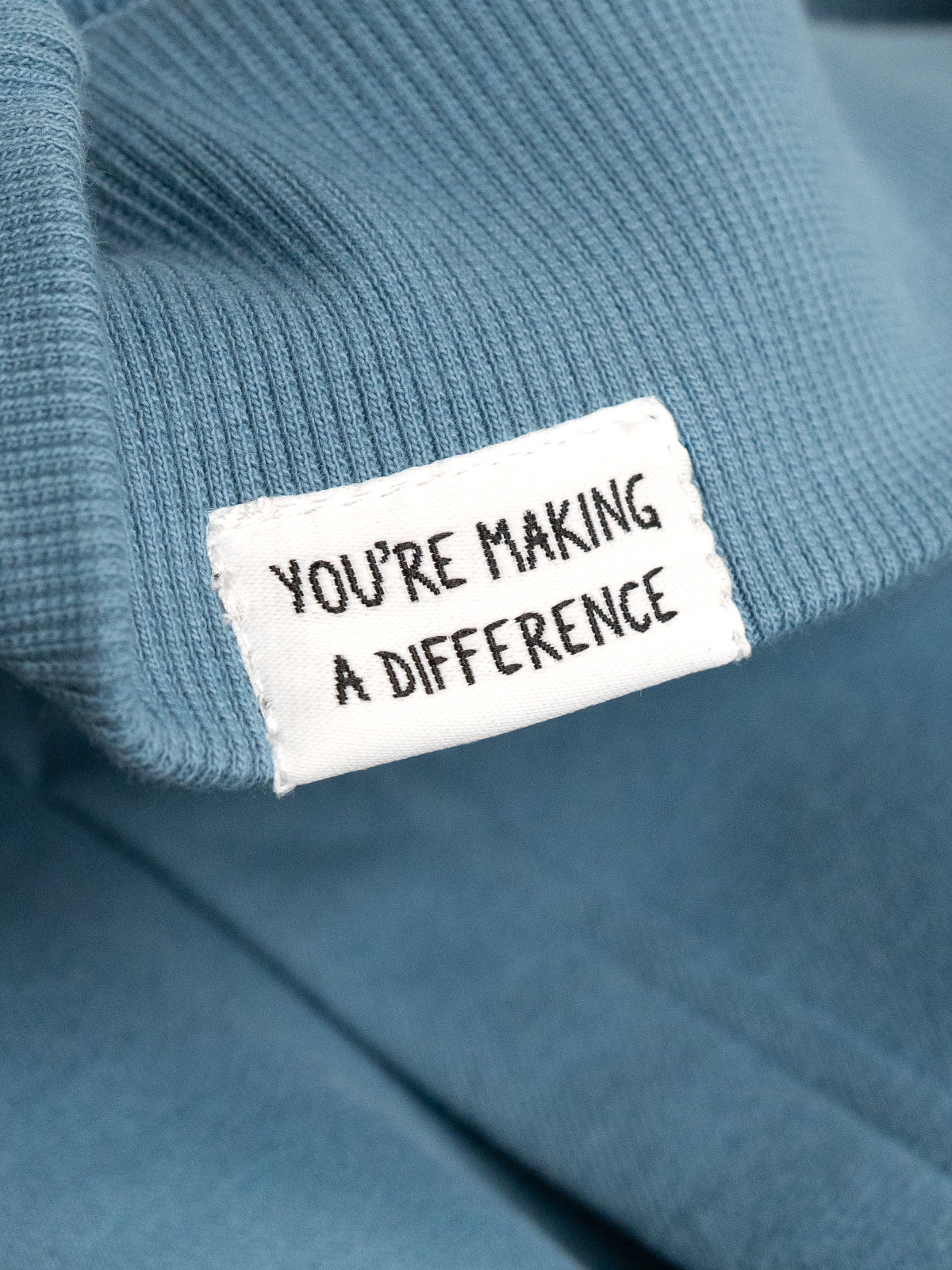 Blue sweater with a label reading 'You're Making a Difference'