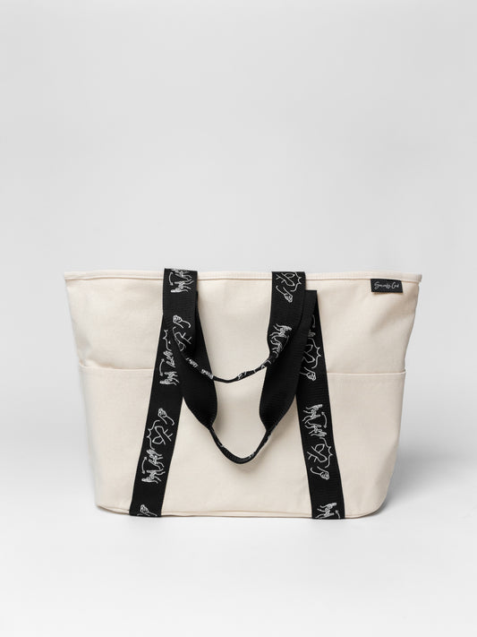 Beige tote bag with black straps on a light gray background