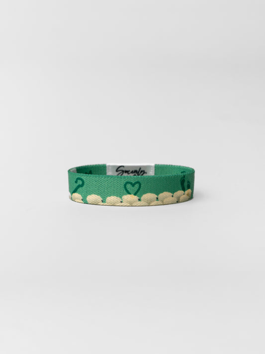 Green bracelet with heart design on a white background