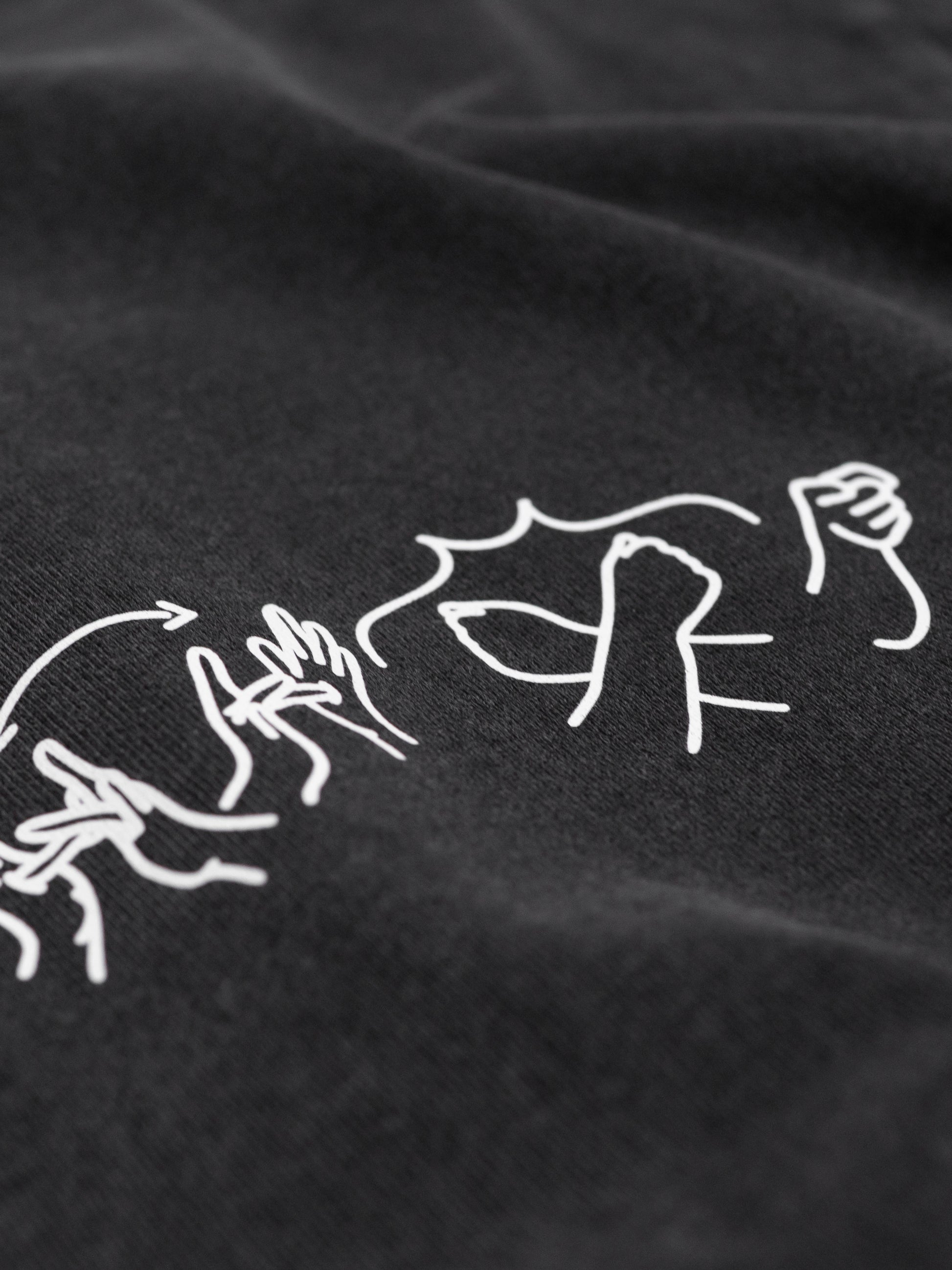 Close-up of a black fabric with white embroidered designs on a dark background