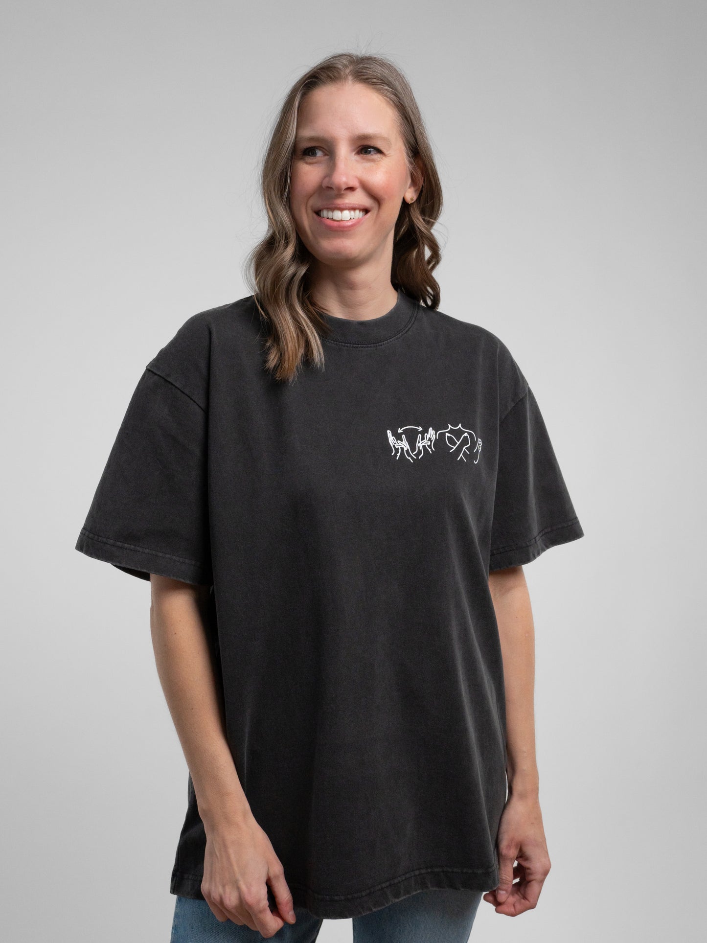 Woman wearing a black t-shirt with a logo on a gray background