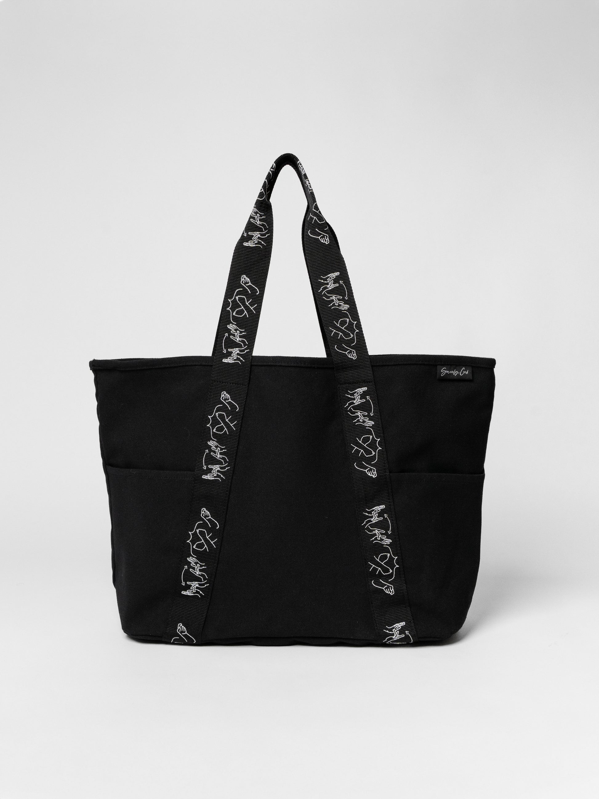 Black tote bag with floral straps on a white background