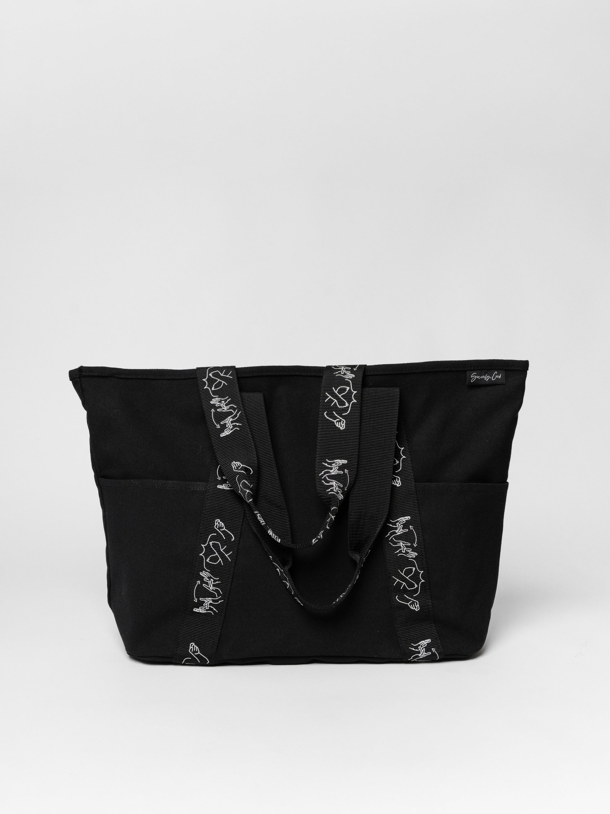 Black tote bag with white patterns on a light gray background