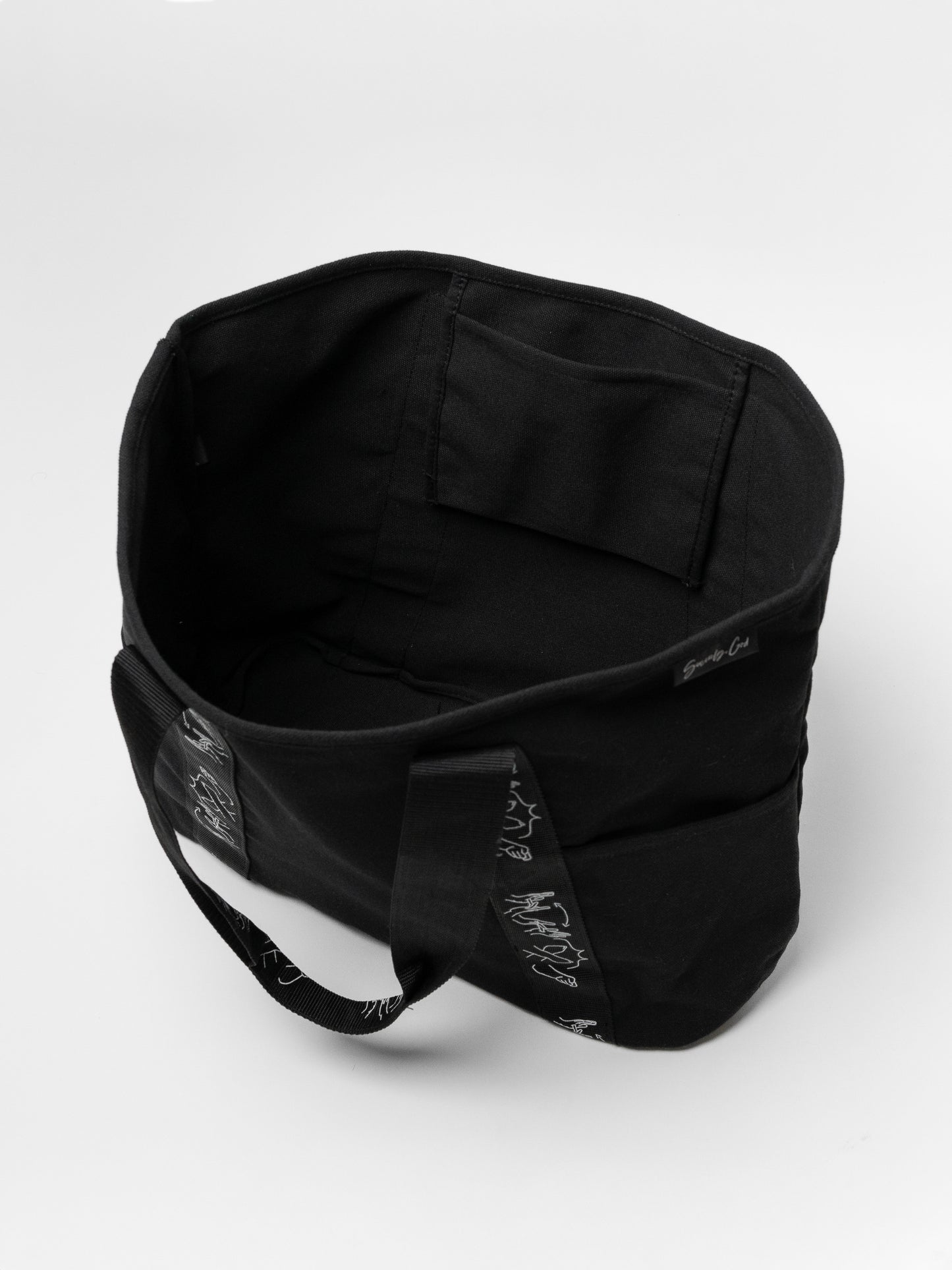 Black duffel bag with white patterns on a light gray background