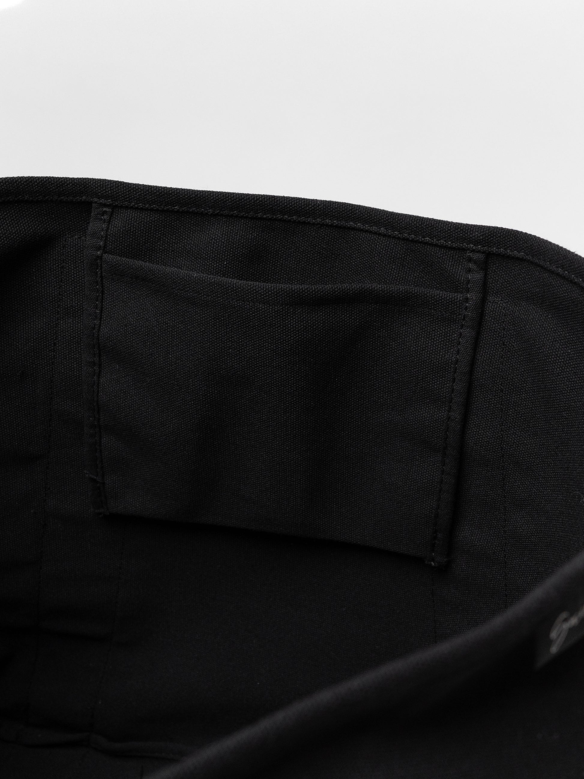 Close-up of a black bag with a pocket on a white background