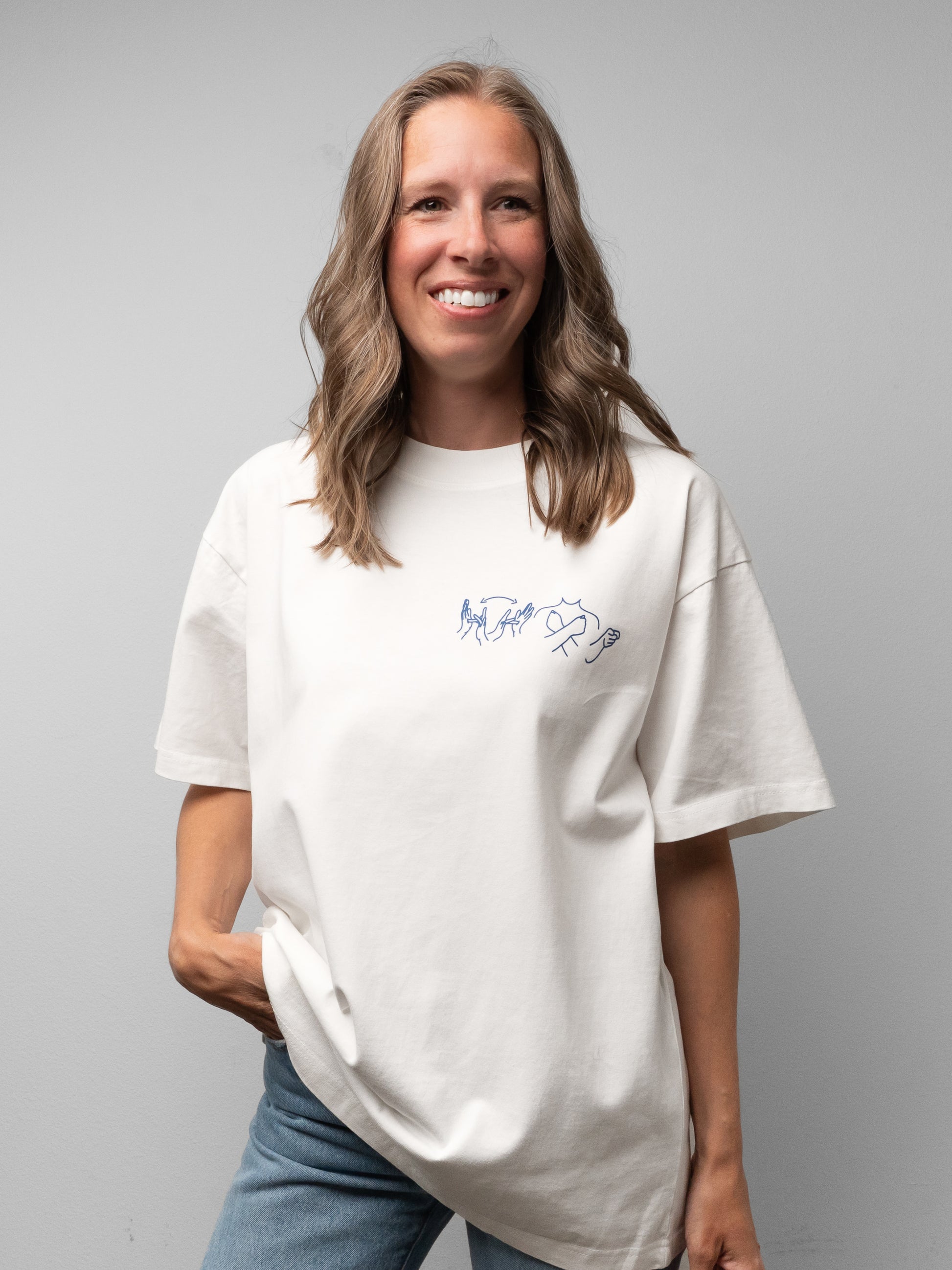 Woman wearing a white t-shirt with a logo on a gray background