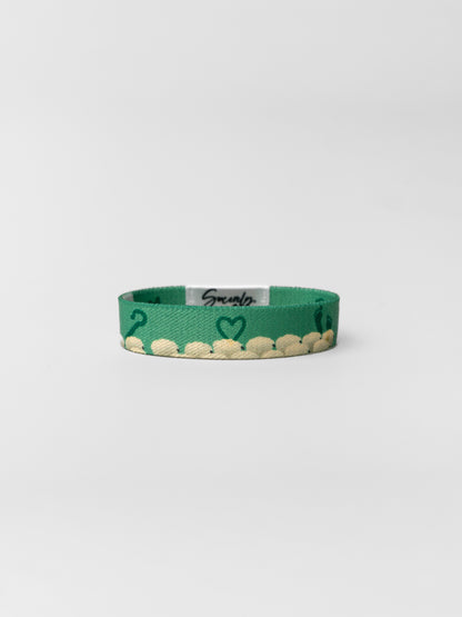 Green bracelet with heart design on a white background