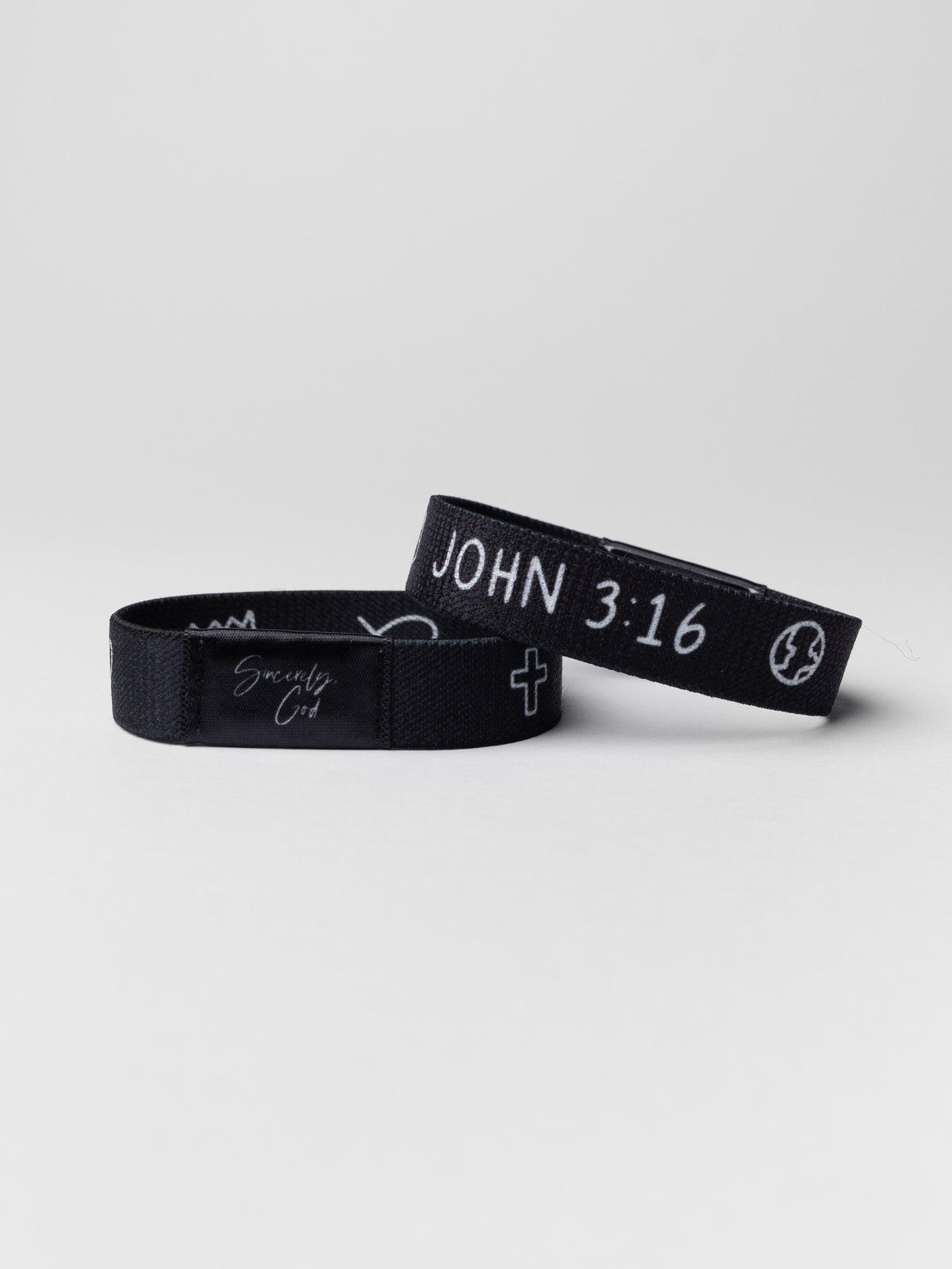 Two black wristbands with text on a light gray background
