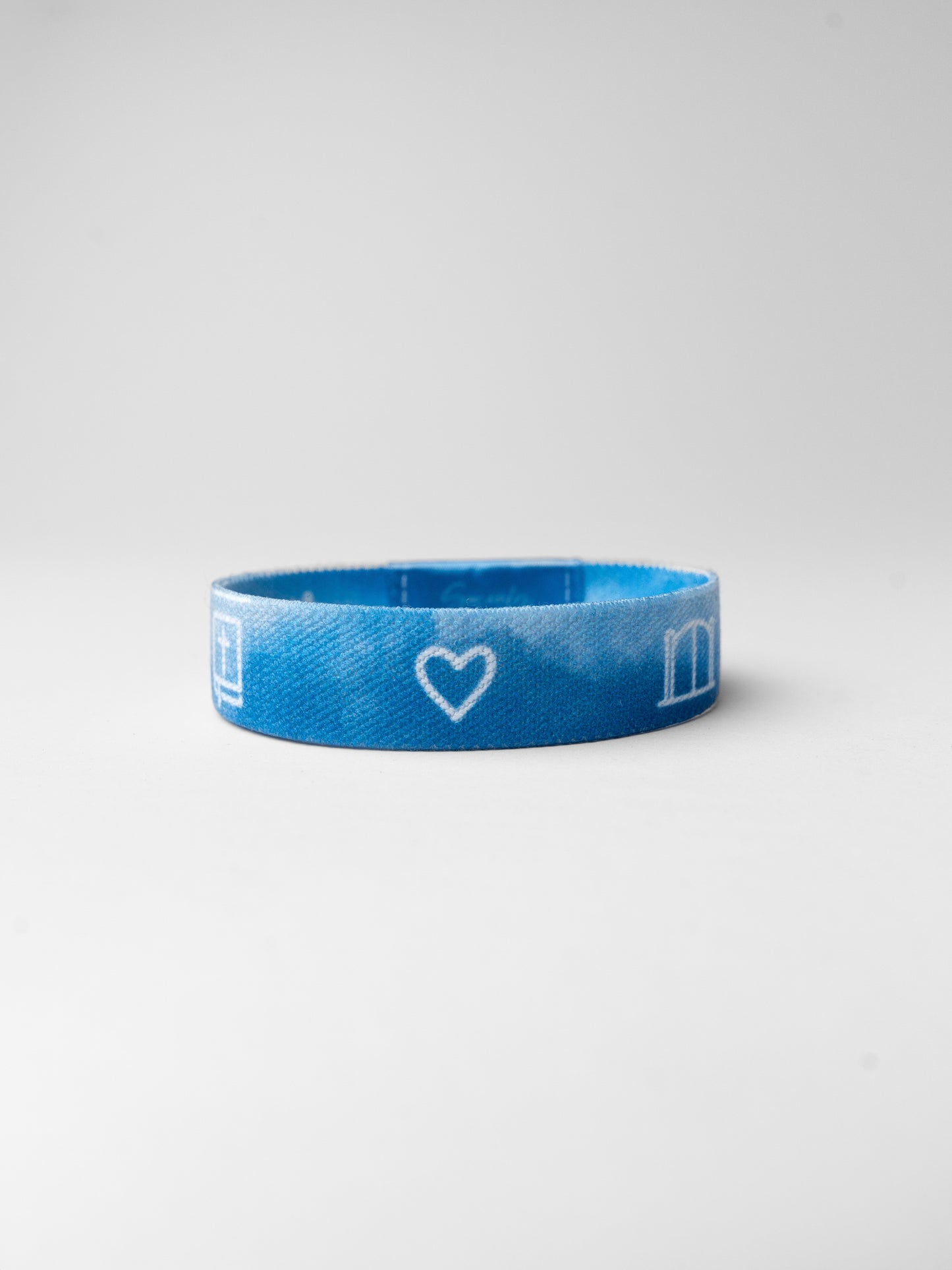 Blue wristband with a heart and letter 'm' on a white background
