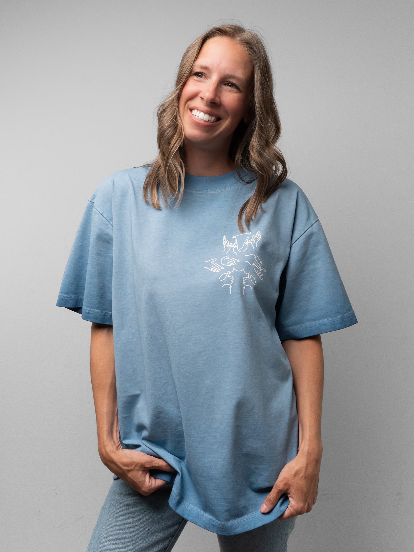 Woman wearing a blue t-shirt with a white graphic design on a gray background