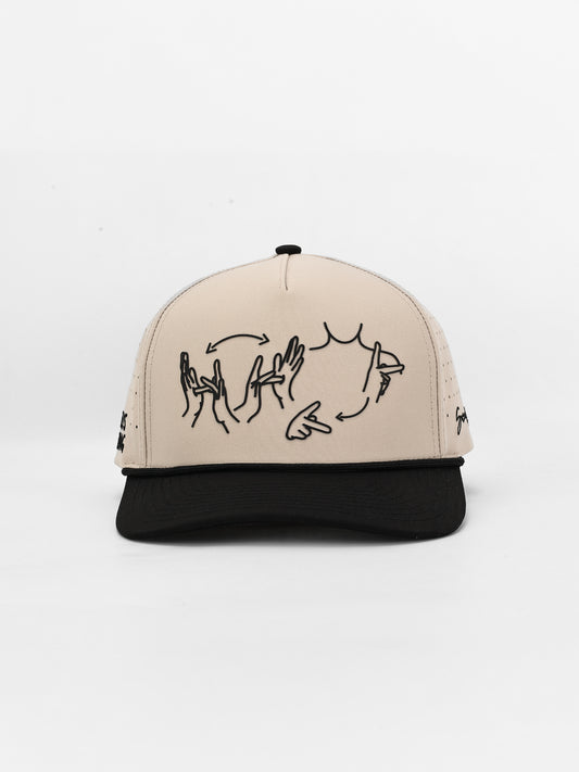 Beige and black cap with hand-drawn designs on a white background