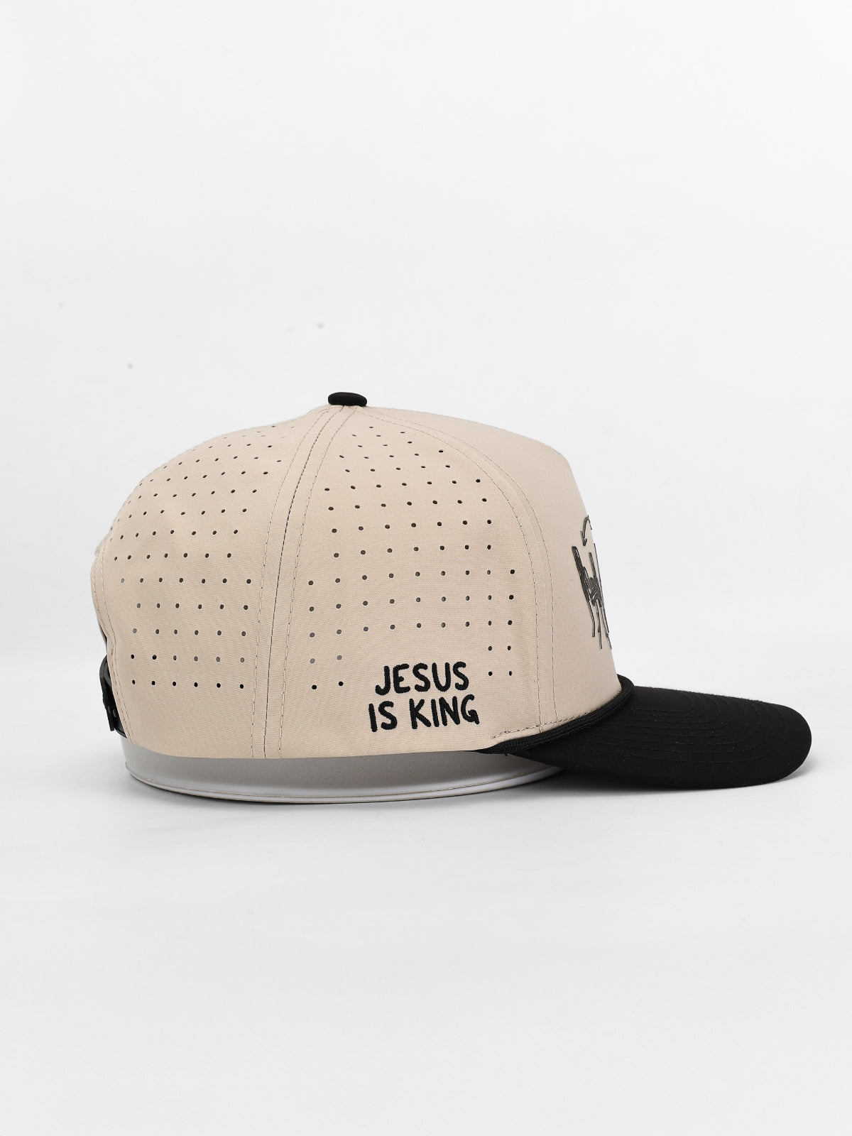 Beige and black cap with 'Jesus is King' text on a white background