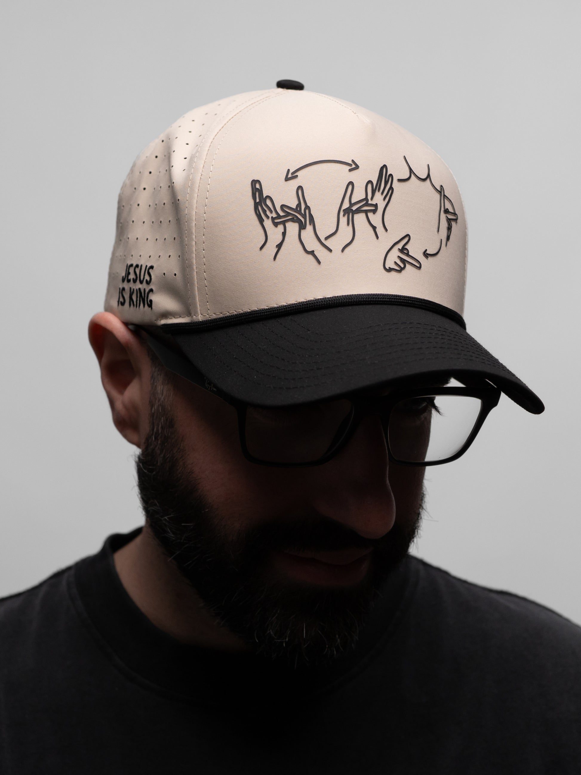 Person wearing a cap with a design and text on a plain background